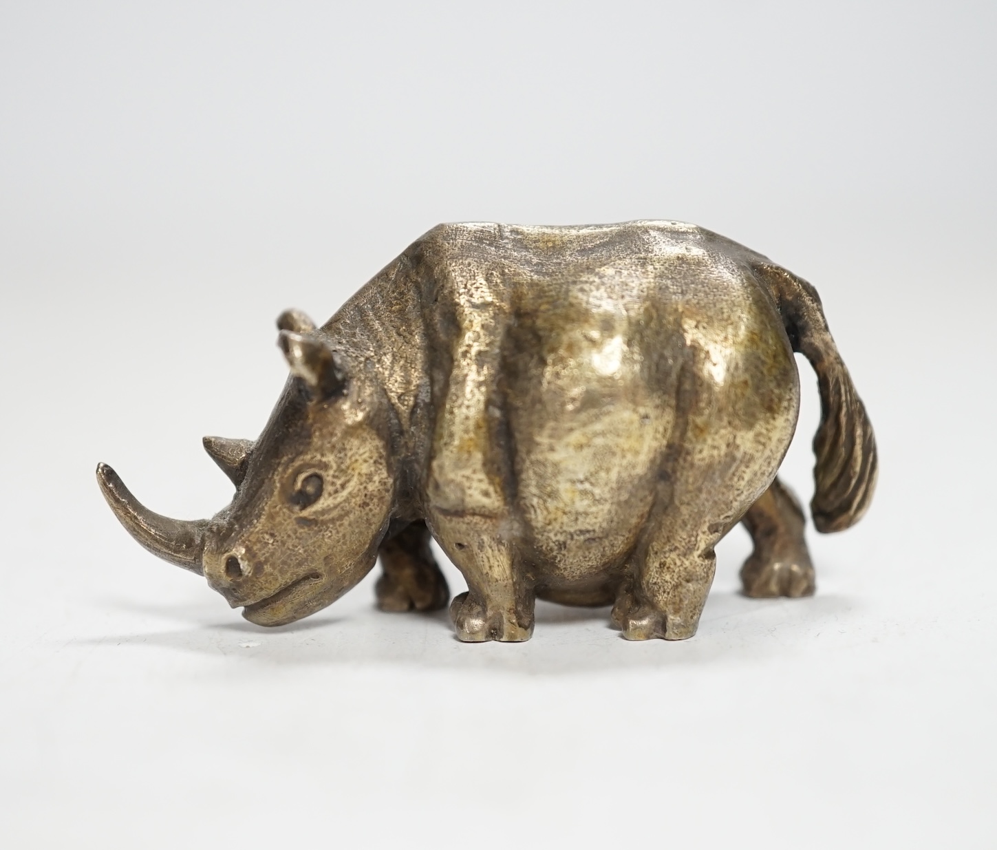 An Elizabeth II silver miniature model of a rhinoceros, by Stuart Devlin, London, 1985, length 55mm.